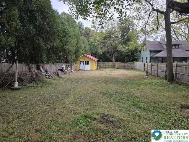 a backyard of a house with large trees and entertaining space