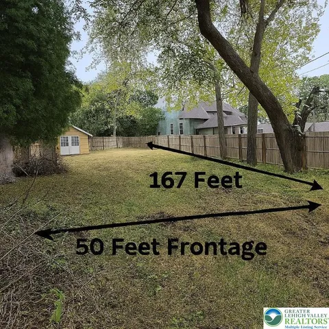 a view of a wooden fence under a large tree
