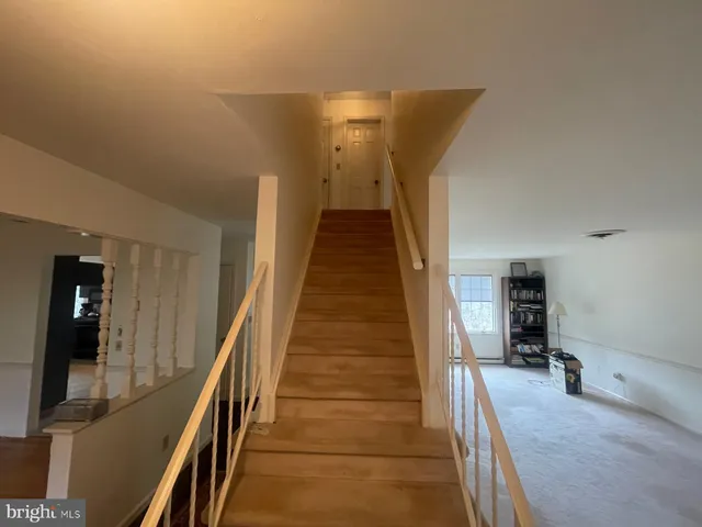 a view of a hallway with wooden floor and stairs