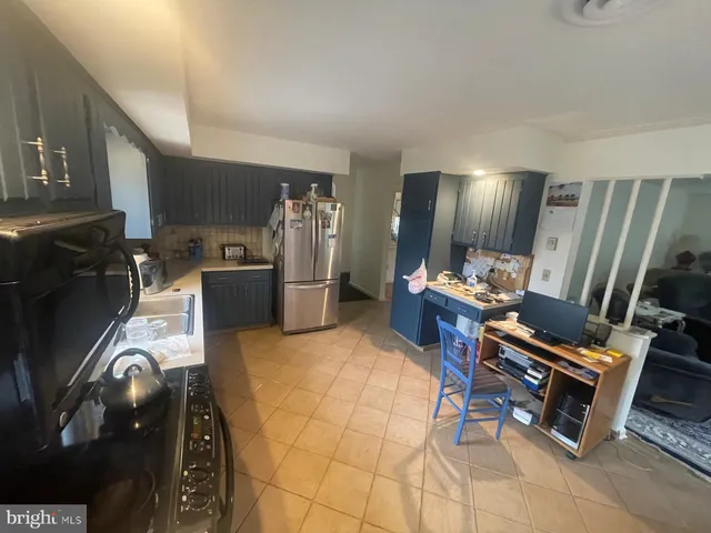 a kitchen with stainless steel appliances kitchen island granite countertop a refrigerator and microwave