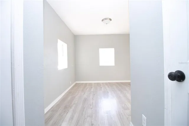 a view of empty room with wooden floor