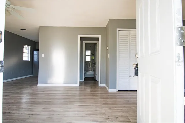 a view of an empty room with wooden floor and closet