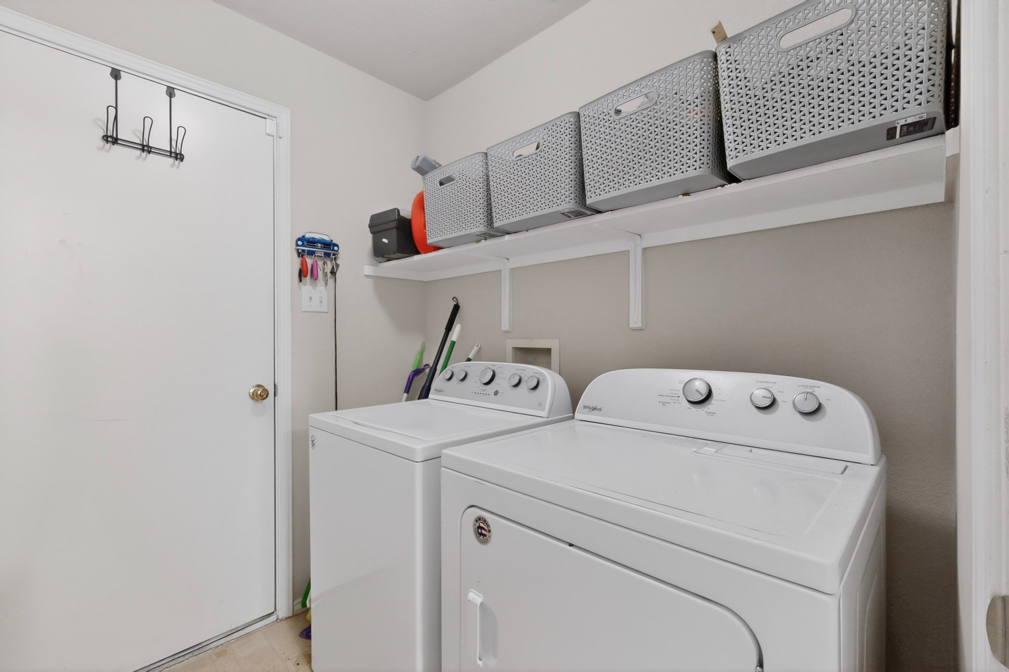 3906 Reeders Drive Austin, TX 78725 - Photo 32 of 36 Dedicated laundry space featuring a white washer and dryer pair, an upper storage shelf, and light-toned wall paint