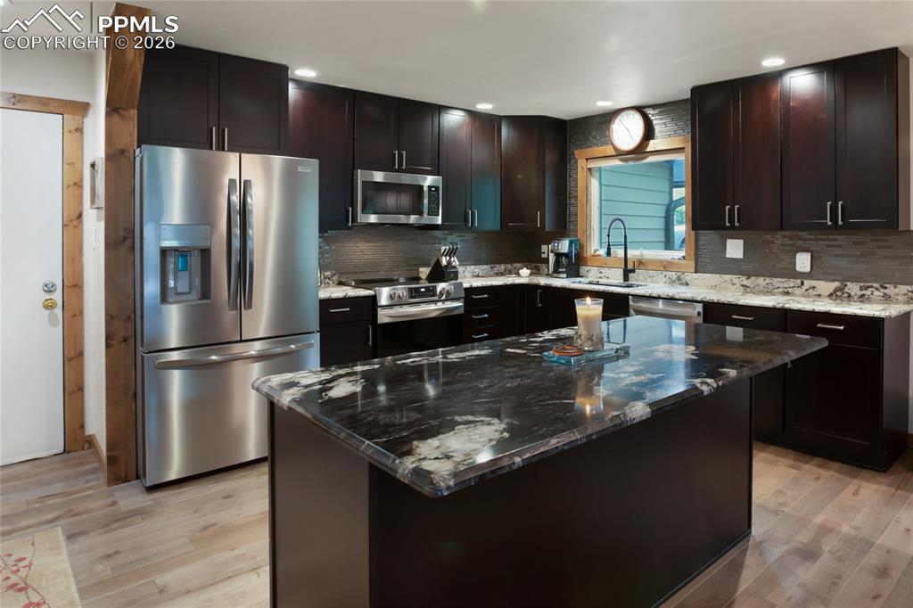 45 Barr Lake Circle Divide, CO 80814 - Photo 5 of 40 a kitchen with kitchen island granite countertop a sink refrigerator and microwave