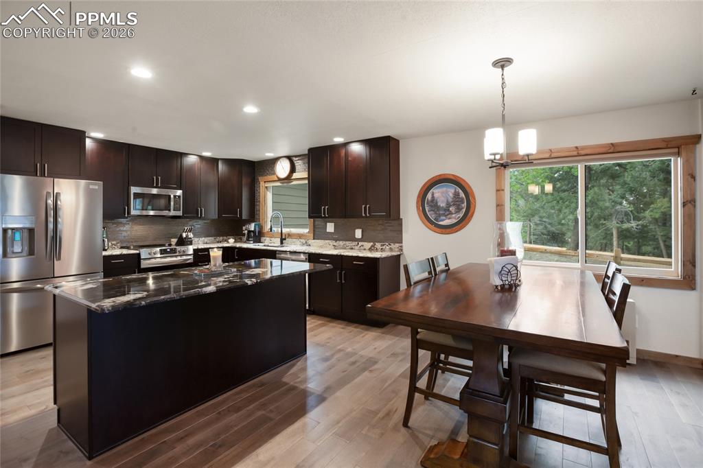 45 Barr Lake Circle Divide, CO 80814 - Photo 6 of 40 a kitchen with granite countertop a table chairs stove refrigerator and cabinets