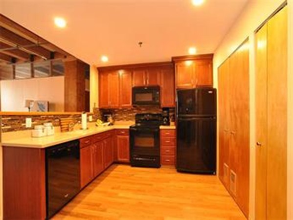33 Sleeper Street, Unit 204 Boston, MA 02210 - Photo 2 of 4 a kitchen with stainless steel appliances granite countertop a refrigerator and a sink
