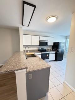 11019 Yorkshire Ridge Court Orlando, FL 32837 - Photo 4 of 15 a kitchen with stainless steel appliances granite countertop a stove a sink and a microwave