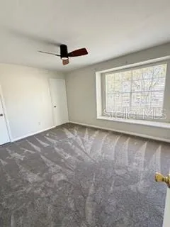 a view of a livingroom with wooden floor and ceiling fan