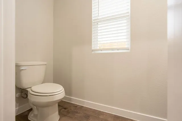 a white toilet sitting next to a window