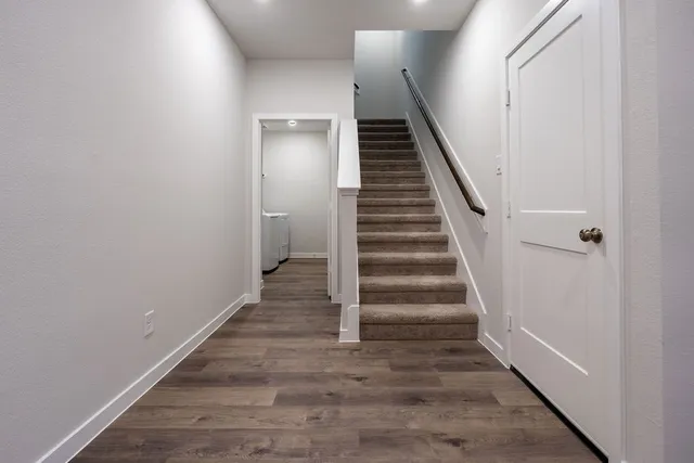 a view of a hallway with wooden floor and entryway