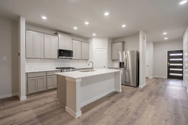 a kitchen with refrigerator cabinets and a sink