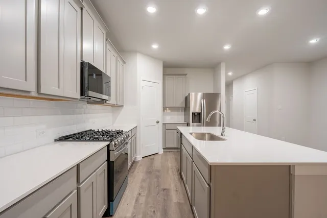 a kitchen with a sink stove and microwave