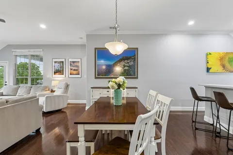 a view of a dining room with furniture a chandelier and wooden floor