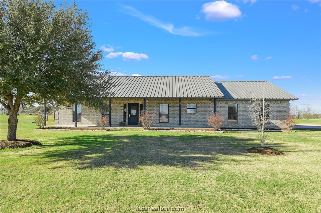 a front view of a house with a garden and trees