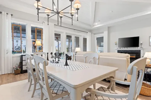 a view of a dining room with furniture a fireplace and wooden floor
