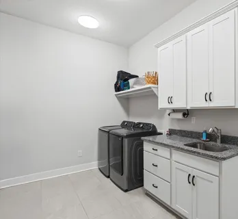 a kitchen with granite countertop white cabinets and stainless steel appliances
