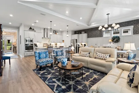 a living room with lots of furniture and kitchen view