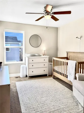 a spacious bedroom with a bed a chandelier and couch