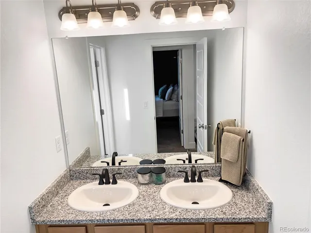 a bathroom with a granite countertop sink and a mirror