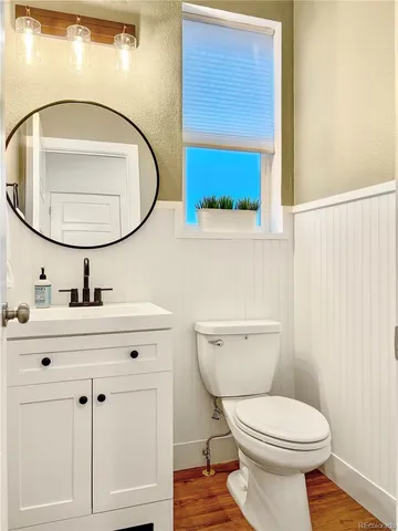 a bathroom with a toilet a sink and mirror