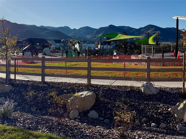 a view of a swimming pool with a table and chairs under an umbrella