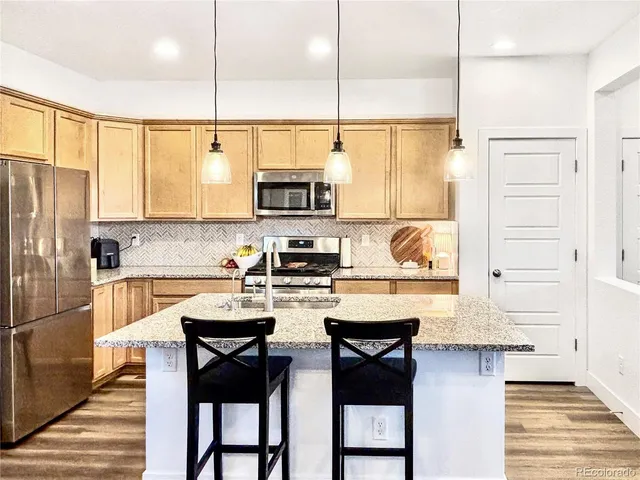 a kitchen with stainless steel appliances a stove a sink refrigerator and a cabinets