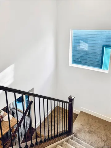 a view of staircase with railing and white walls
