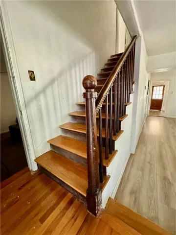 a view of staircase with wooden floor and a rug