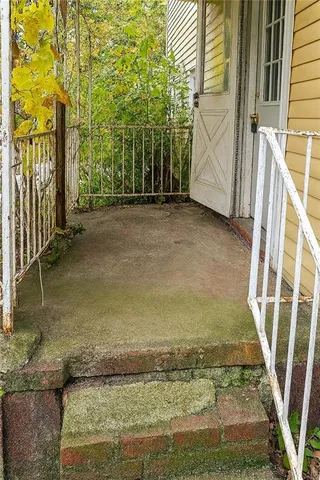 a view of a yard with plants and wooden fence