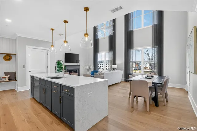 a large kitchen with stainless steel appliances a table chairs and a view of living room
