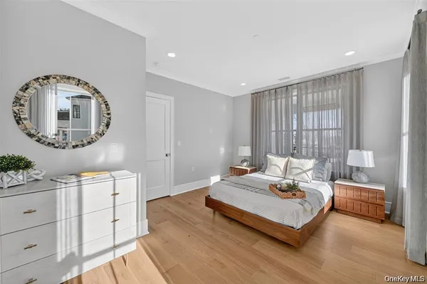 a bedroom with a bed a mirror and a potted plant