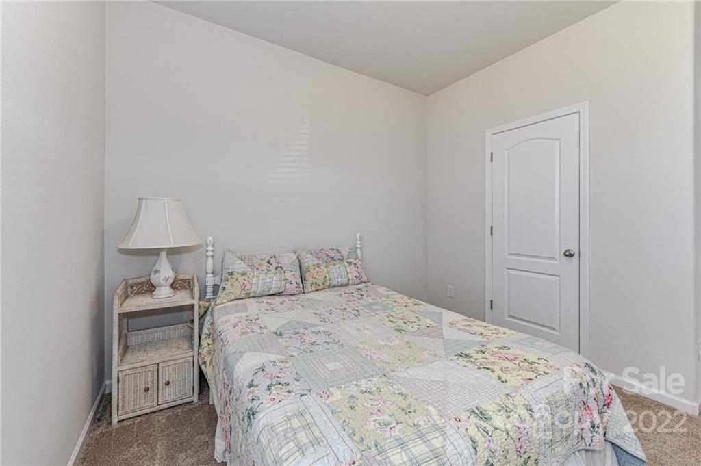 6727 Jerimoth Charlotte, NC 28215 - Photo 22 of 30 a bedroom with a bed and a lamp on the dresser