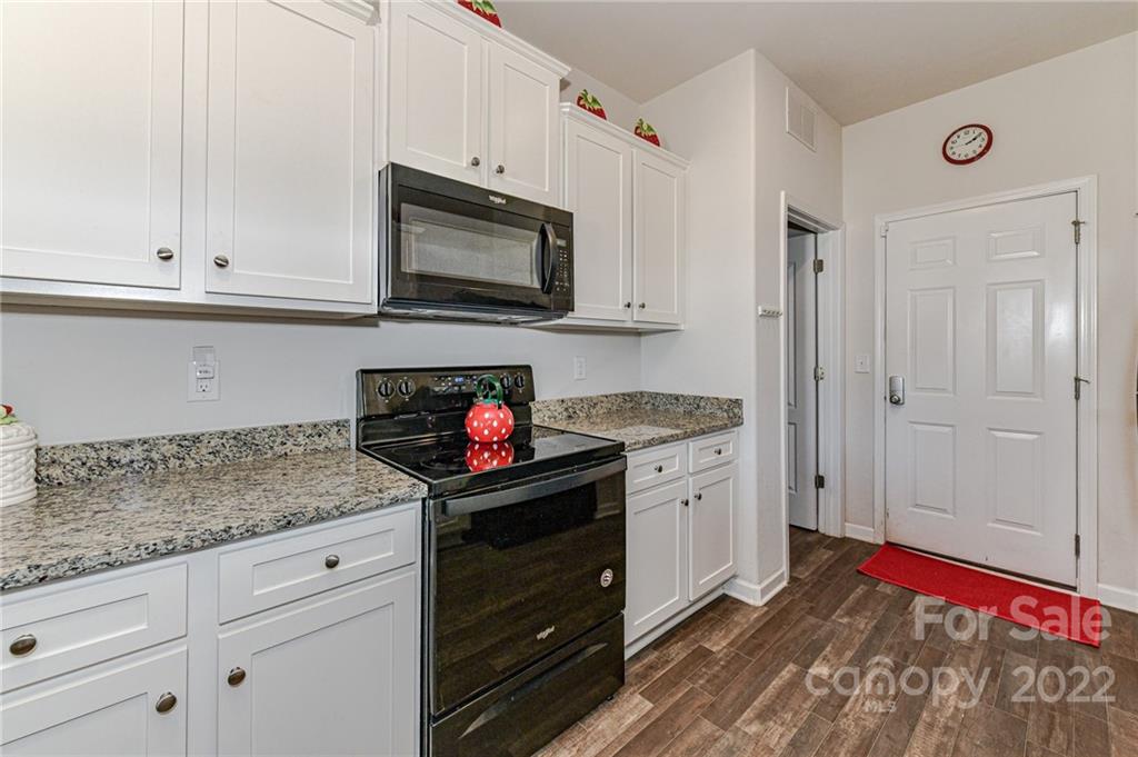 6727 Jerimoth Charlotte, NC 28215 - Photo 10 of 30 a kitchen with granite countertop white cabinets and stainless steel appliances