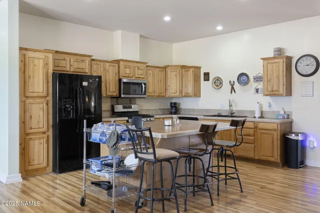 a kitchen with granite countertop a refrigerator stove top oven and sink