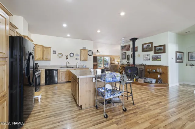 a living room with stainless steel appliances furniture and a kitchen view