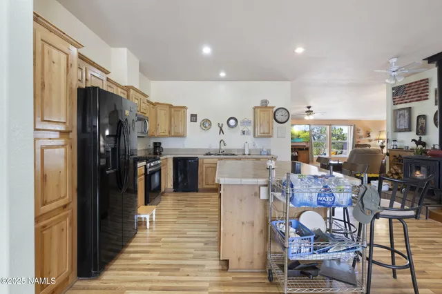 a open kitchen with stainless steel appliances kitchen island granite countertop a refrigerator and cabinets