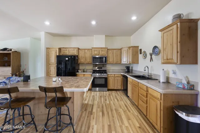 a kitchen with a sink a counter top space stainless steel appliances and cabinets