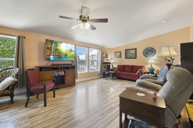 a living room with furniture a flat screen tv and a large window
