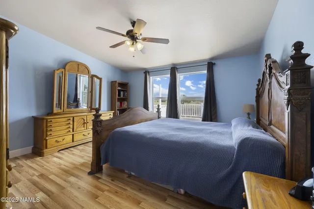 a bedroom with a bed a dresser and wooden floor