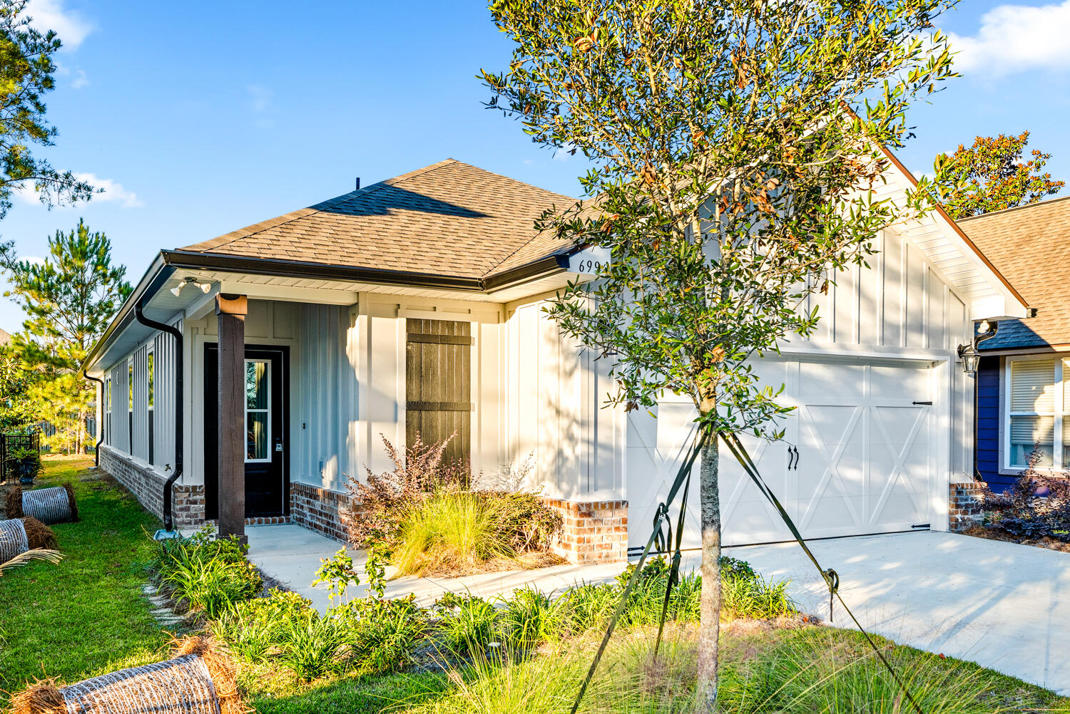 a view of a house with a small yard and large tree