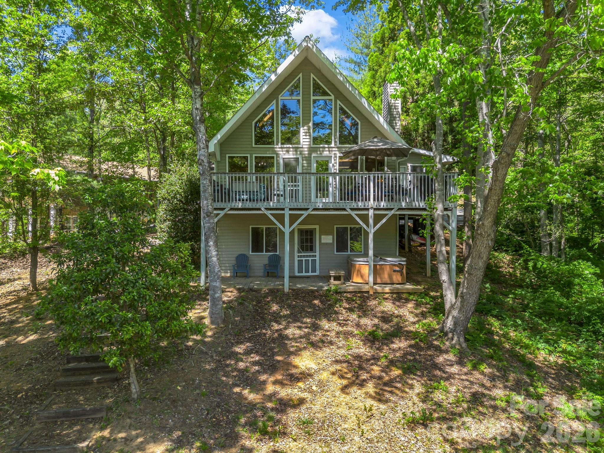 268 Mallard Road Lake Lure, NC 28746 - Photo 1 of 44 a view of a big house with a small yard and large trees