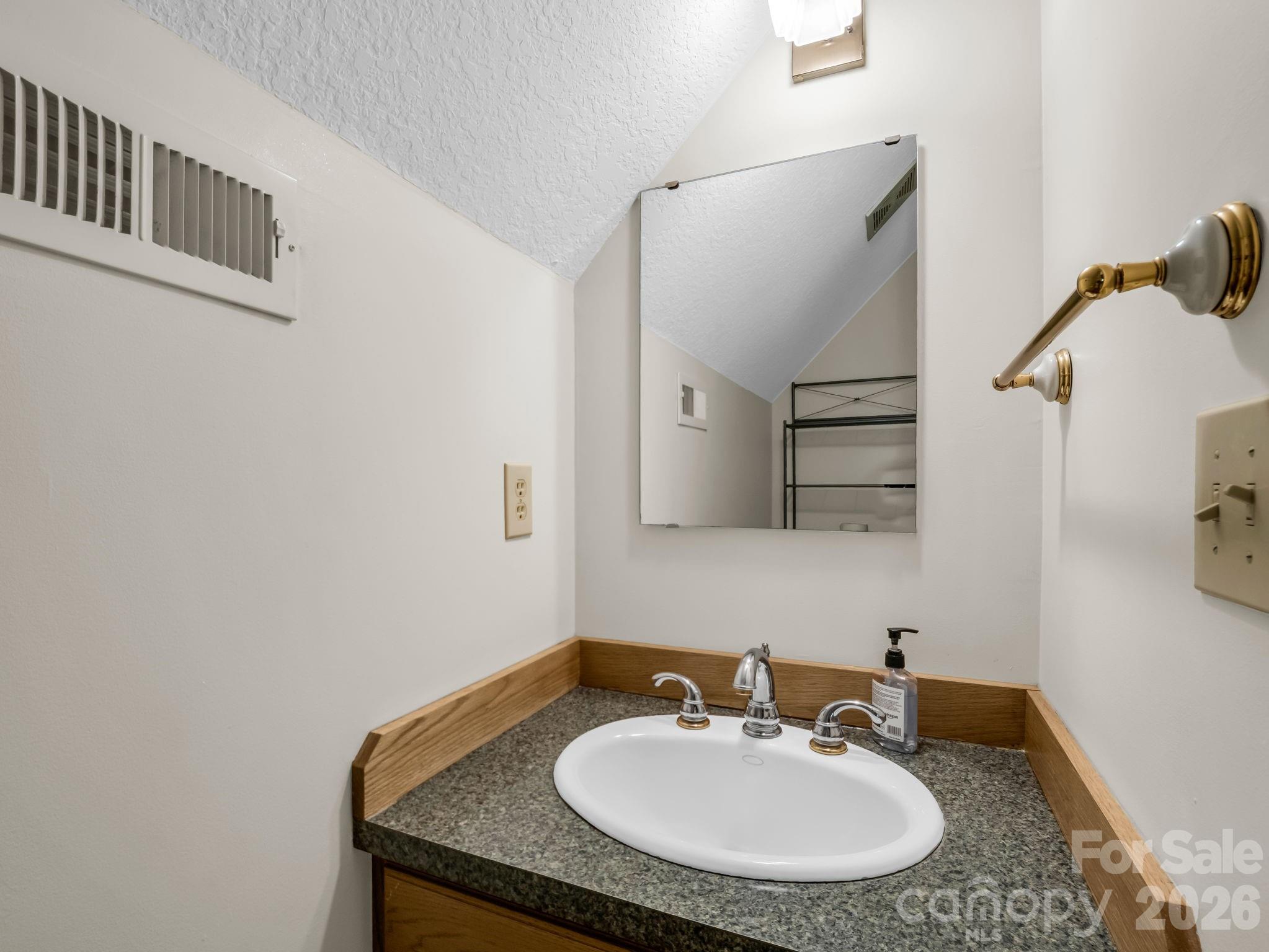 268 Mallard Road Lake Lure, NC 28746 - Photo 27 of 44 a bathroom with a granite countertop sink and a mirror