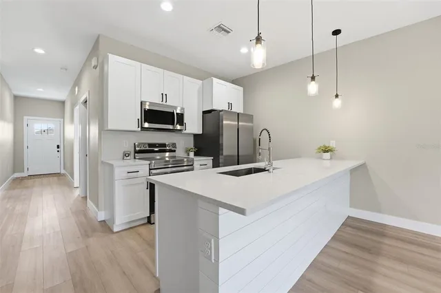 a kitchen with refrigerator cabinets and wooden floor