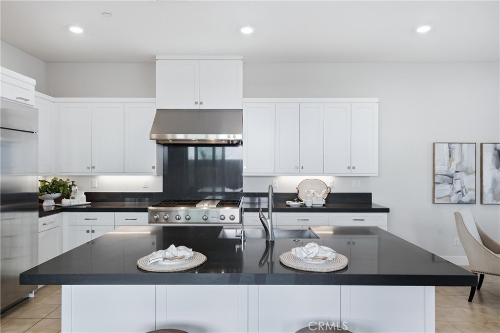 182 Scale Irvine, CA 92618 - Photo 20 of 61 kitchen is serious about dinner. Dark quartz. Clean lines. Two place settings ready.