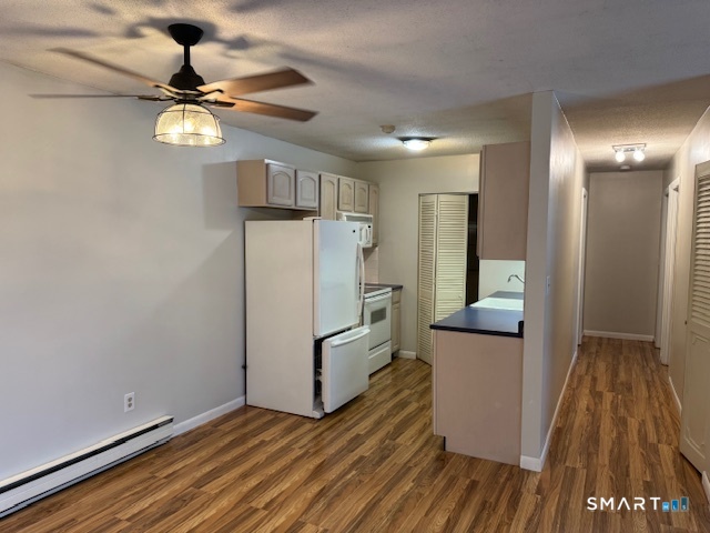 74 Buddington Road, Unit 7 Groton, CT 06340 - Photo 6 of 19 a view of a kitchen with wooden floor and a ceiling fan