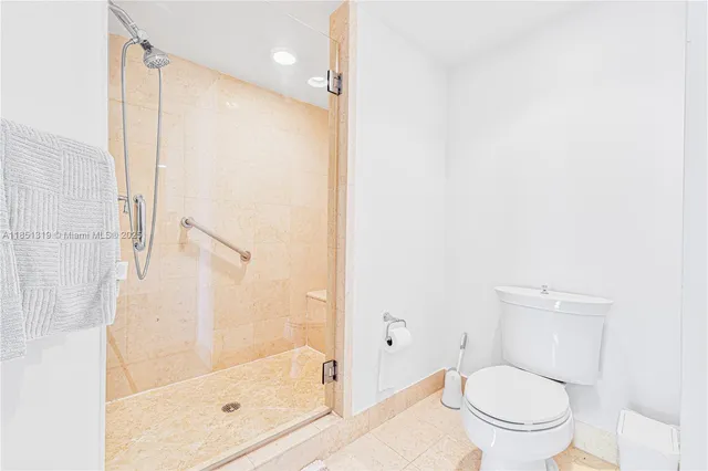 a bathroom with a granite countertop bathtub shower and toilet