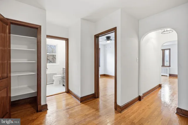 a view of a hallway with wooden floor and closet