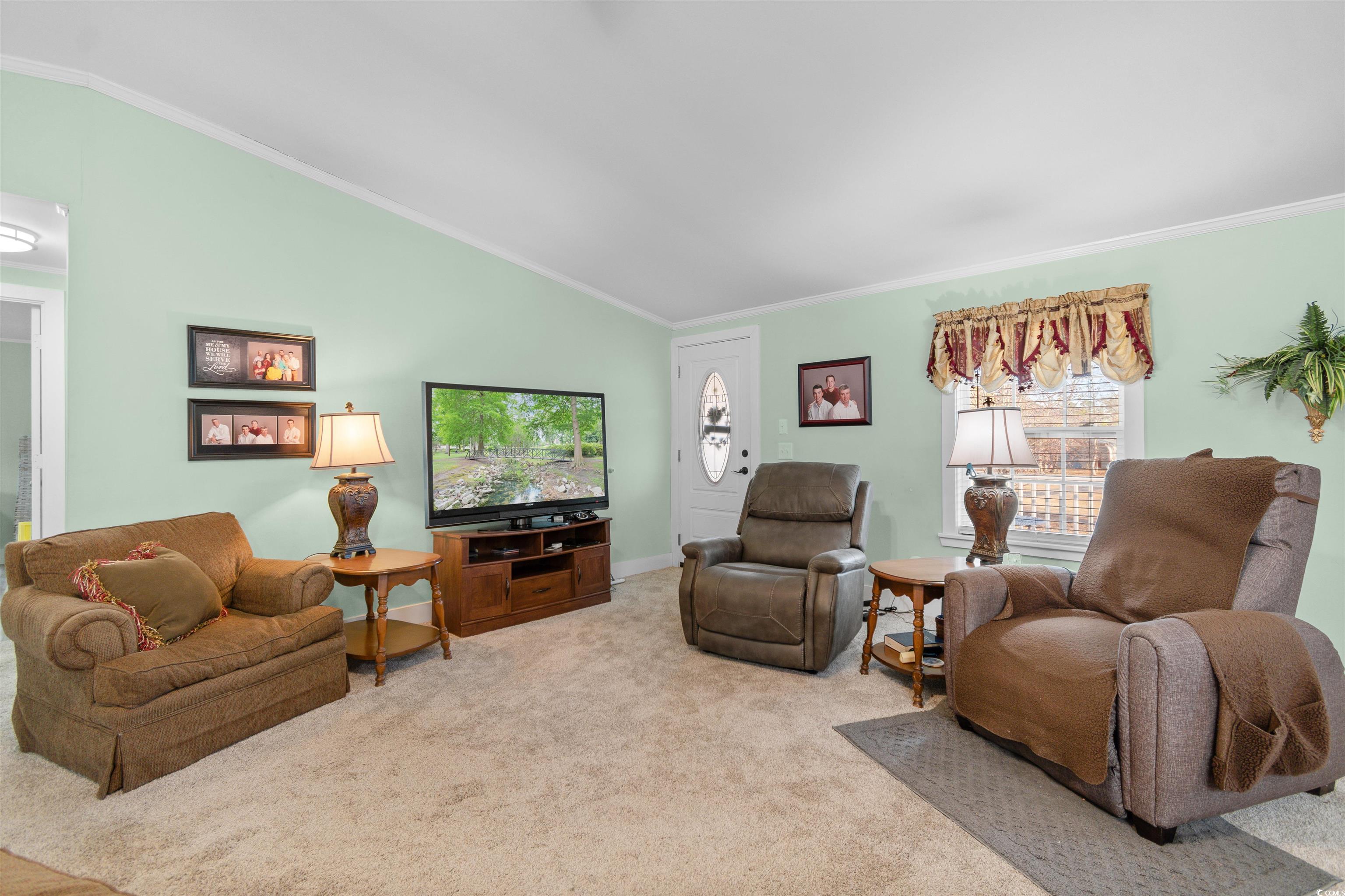 4065 Highway 66 Loris, SC 29569 - Photo 10 of 40 Carpeted living area featuring crown molding and vaulted ceiling