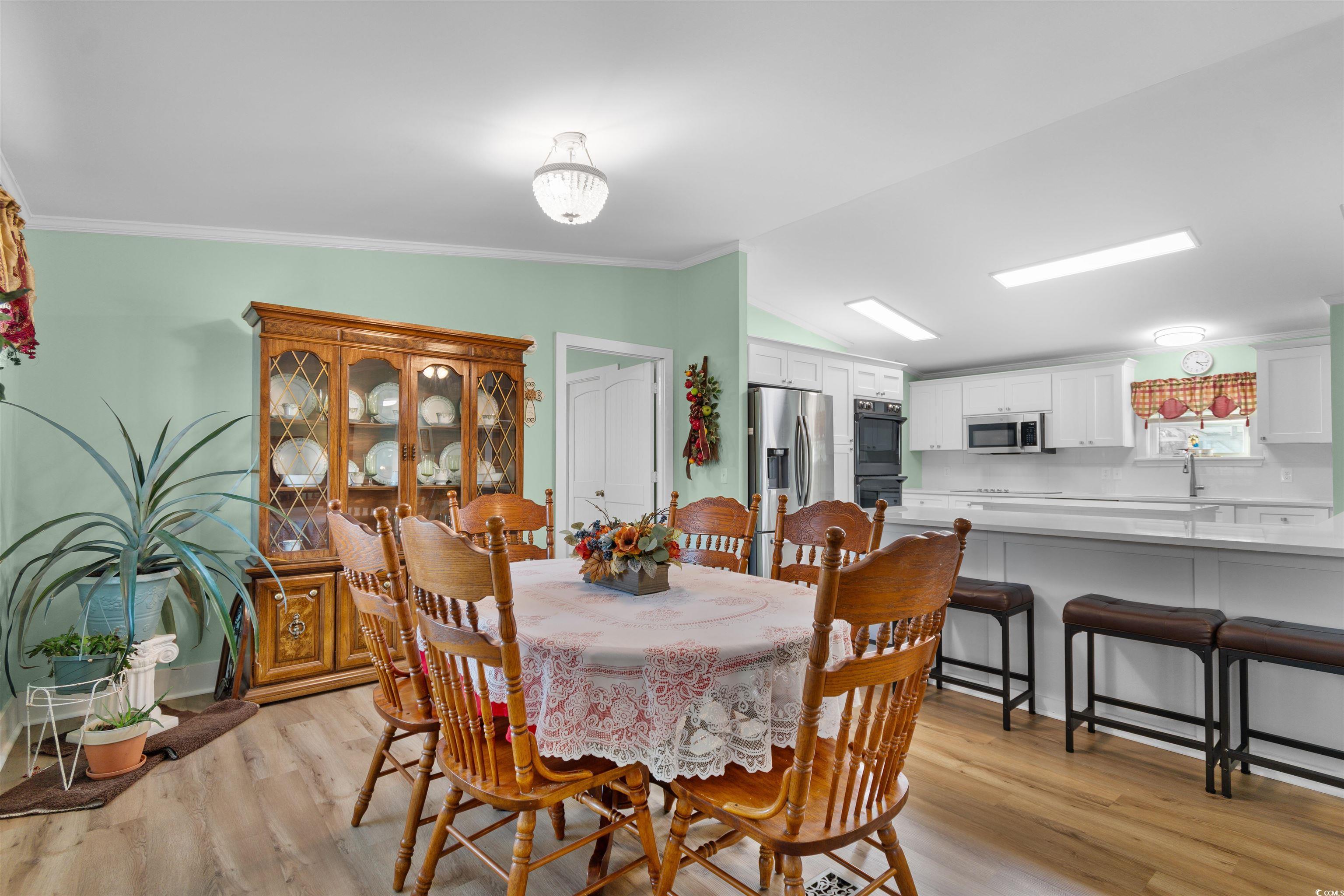 4065 Highway 66 Loris, SC 29569 - Photo 11 of 40 Dining room with lofted ceiling, light wood-style floors, and crown molding