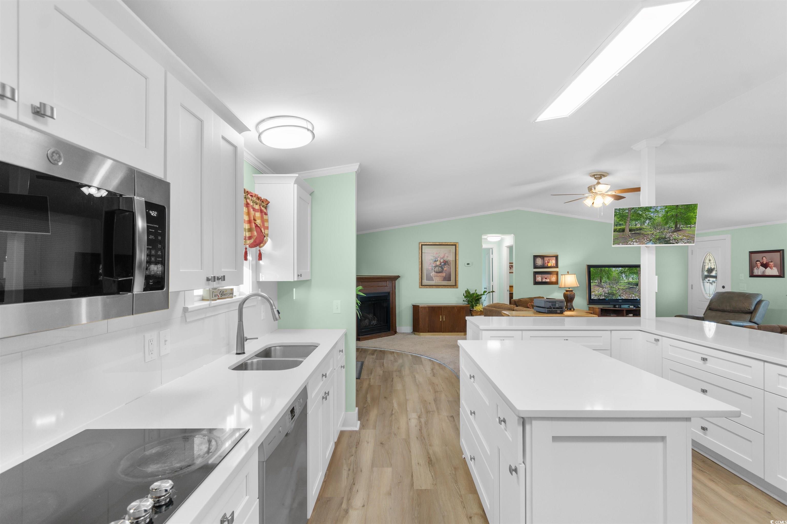 4065 Highway 66 Loris, SC 29569 - Photo 39 of 40 Kitchen with open floor plan, white cabinetry, a kitchen island, ornamental molding, and vaulted ceiling